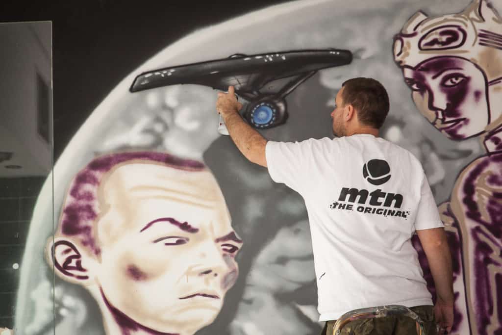 Graffiti artist painting mural